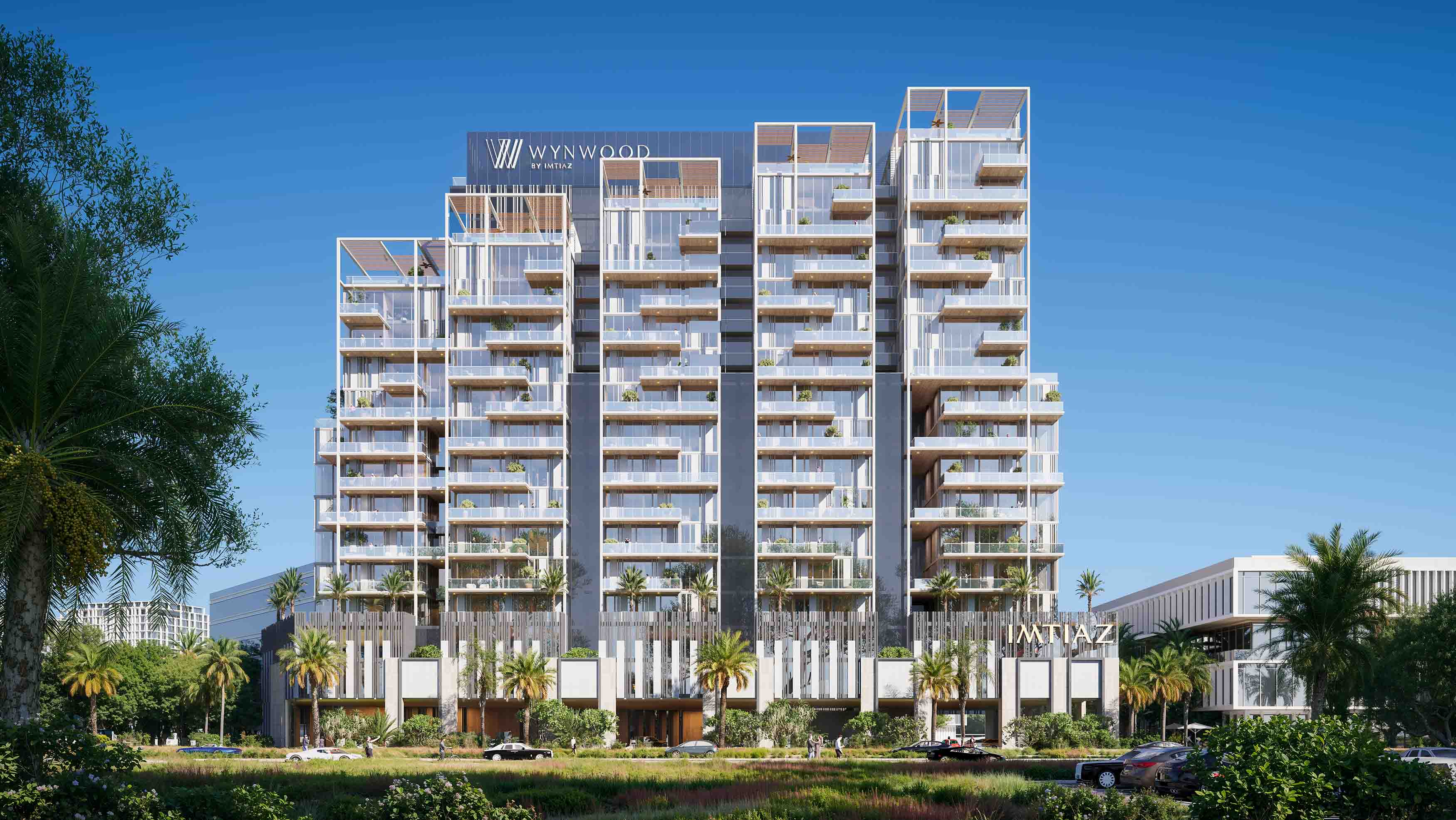 Wynwood By Imtiaz Modern residential building with balconies, greenery, and palm trees, set against a clear blue sky.